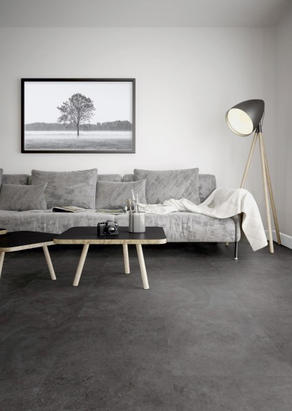 Fliesenoptik Vinyl in grau im Wohnzimmer mit hellgrauer Couch, schwarzem Beistelltisch und schwarzem Bild an der Wand
